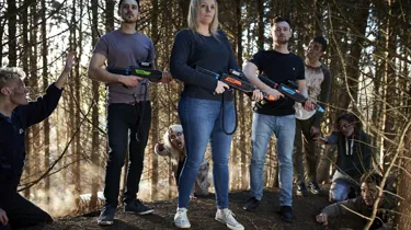 Zombie Hunt, group standing ready with guns and zombies lurching towards them