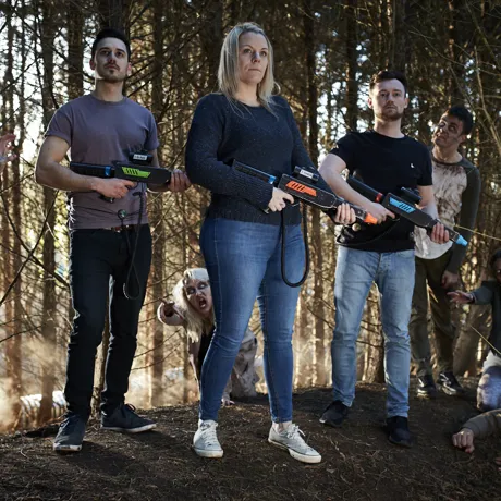 Zombie Hunt, group standing ready with guns and zombies lurching towards them
