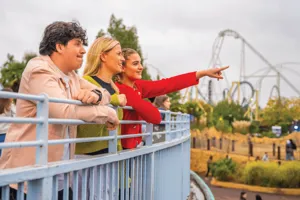 3 guests stood on a balcony looking over towards the Thorpe Park