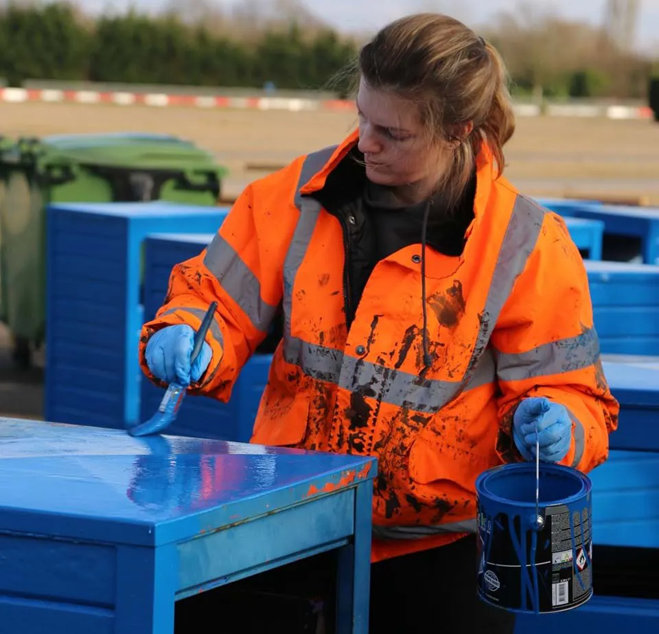 Employee repainting a bin