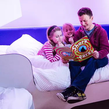 Thorpe Shark Cabins, dad reading a bedtime story to his daughters