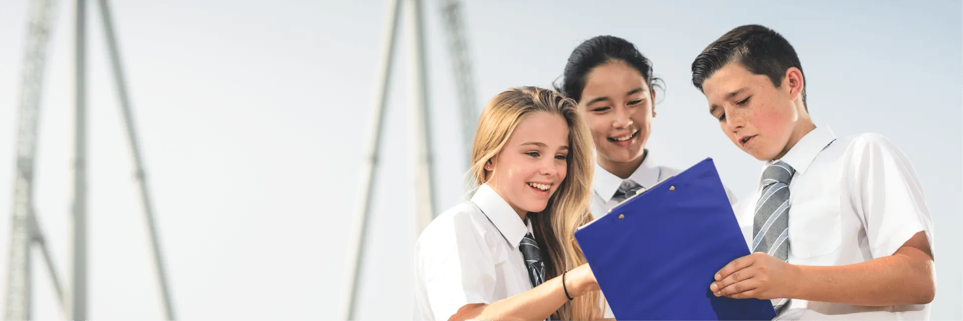 Students Looking At A Clipboard Next To Stealth Rollercoaster